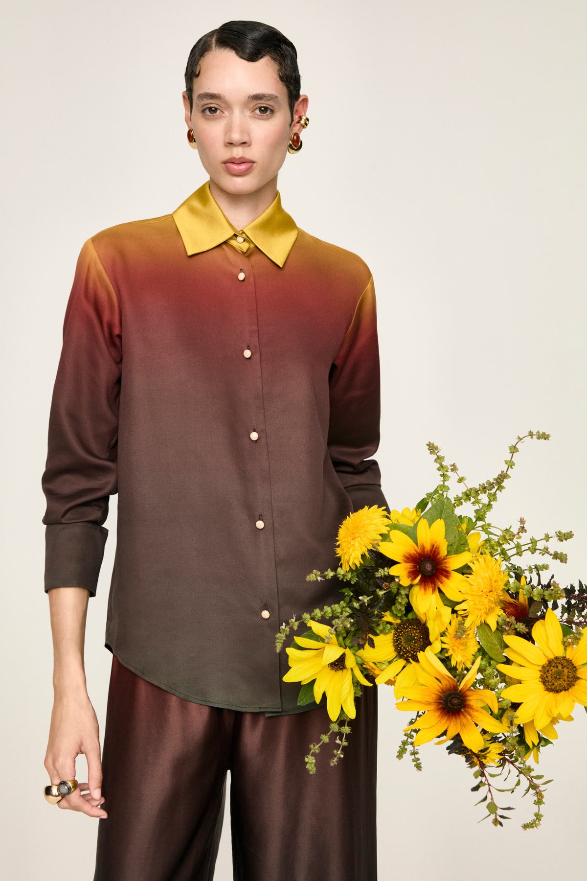 Camicia Luce Terra vista frontale, con un mazzo di girasoli
