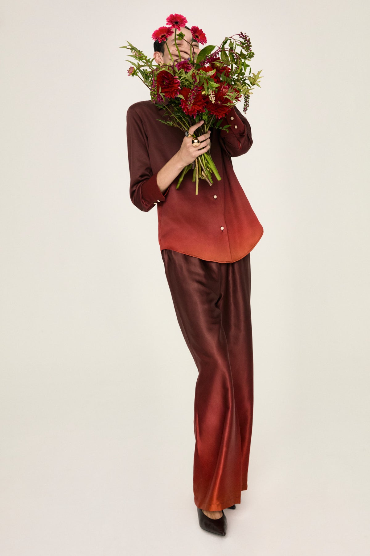 Leto Fuoco trousers with the Luce Fuoco shirt, full-length view with a bouquet of red flowers