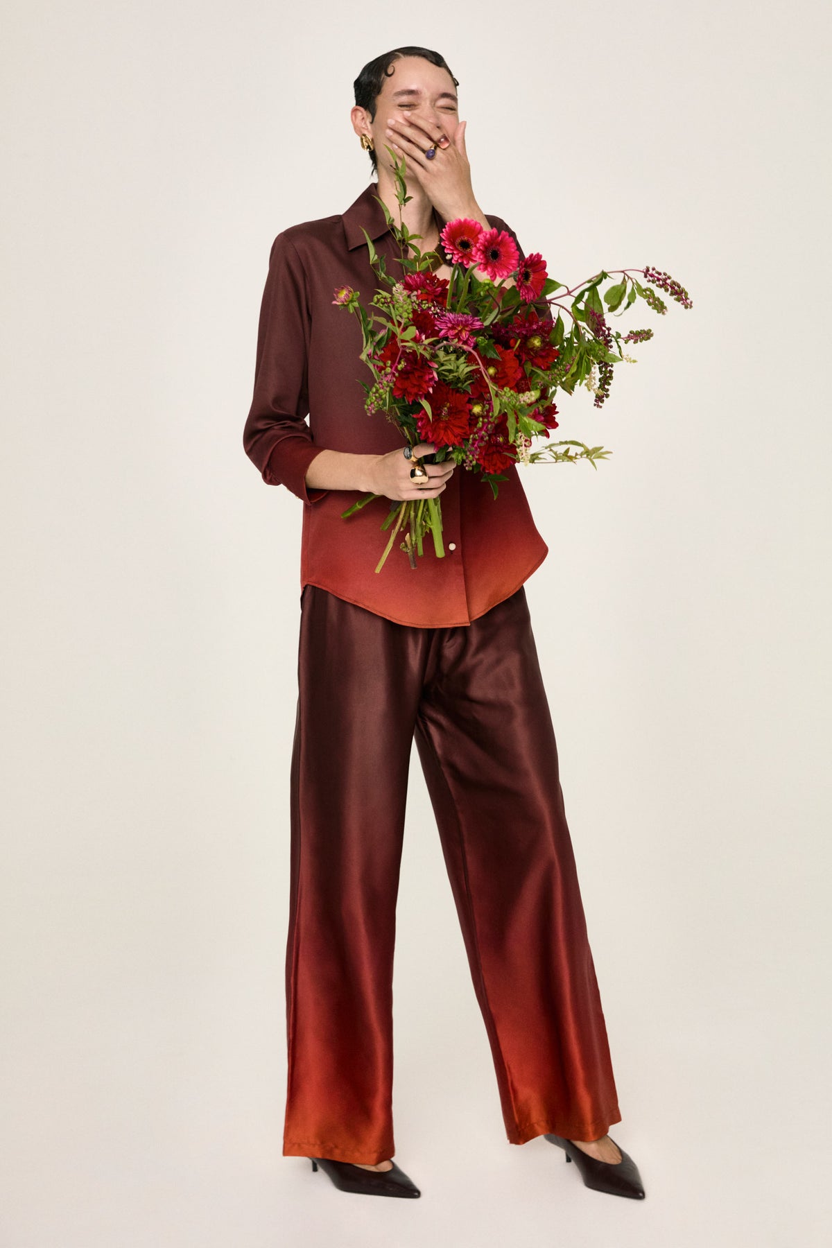 Leto Fuoco palazzo trousers worn, with a bouquet of red flowers at the waist