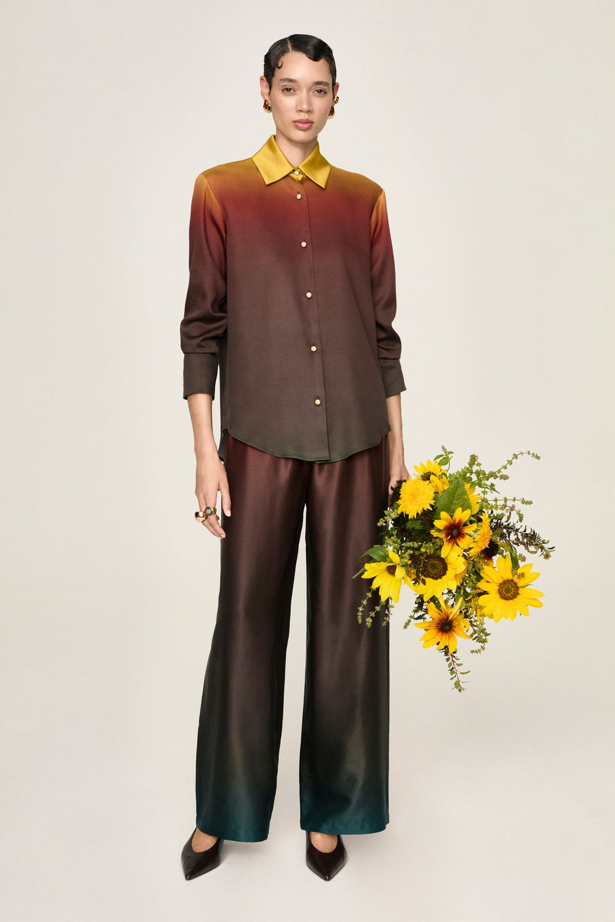 Pantalone Leto Terra con la camicia Luce Terra, figura intera con un mazzo di girasoli